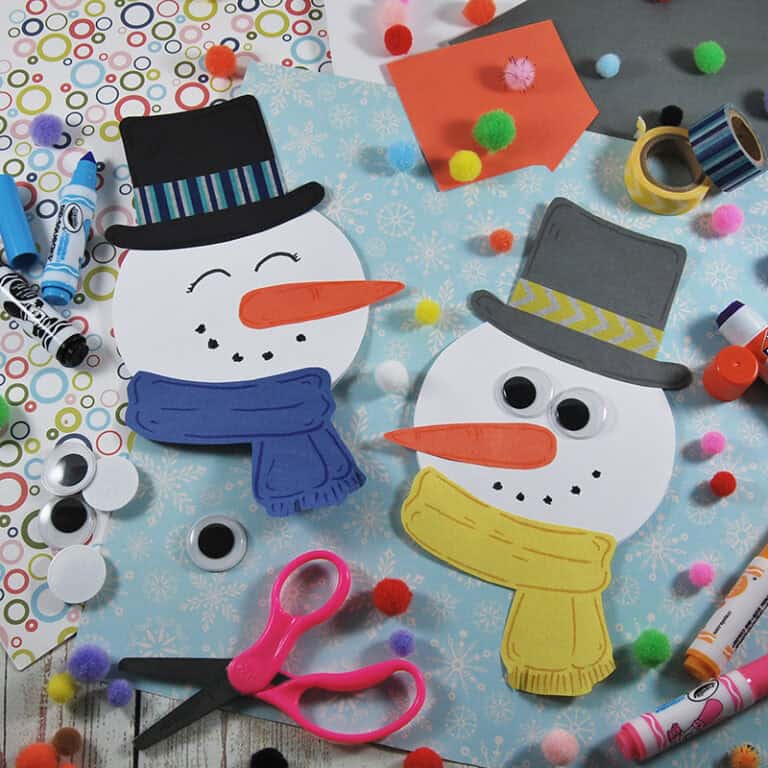 A cheerful handmade snowman card featuring a carrot nose, black hat, and blue scarf, perfect as a winter craft, Christmas craft, or holiday card idea for kids.