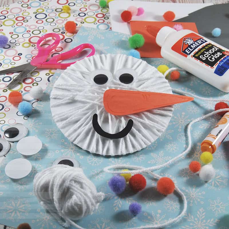 A fun snowman craft made with yarn, googly eyes, and paper materials, perfect as a winter craft and an easy craft for kids.