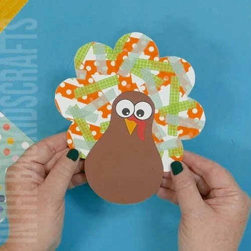 Colorful turkey craft for kids featuring a free turkey outline, ideal as a Thanksgiving craft for preschool and kindergarten children. washi tape feathers turkey art