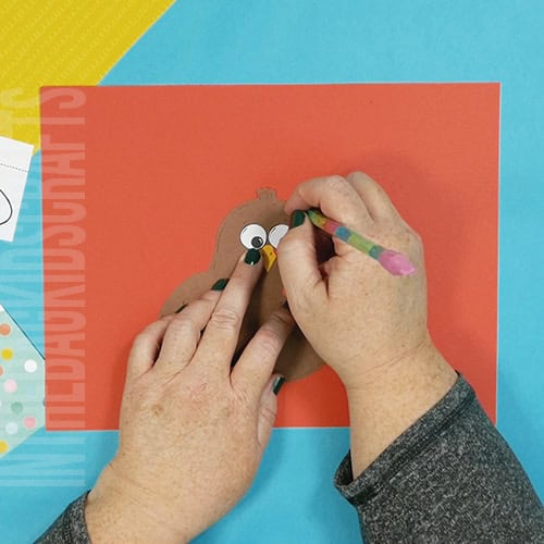 A colorful and simple turkey craft for kids featuring a cut-and-paste design, ideal for preschool craft and fall-themed Thanksgiving activities. step 3 marking the page