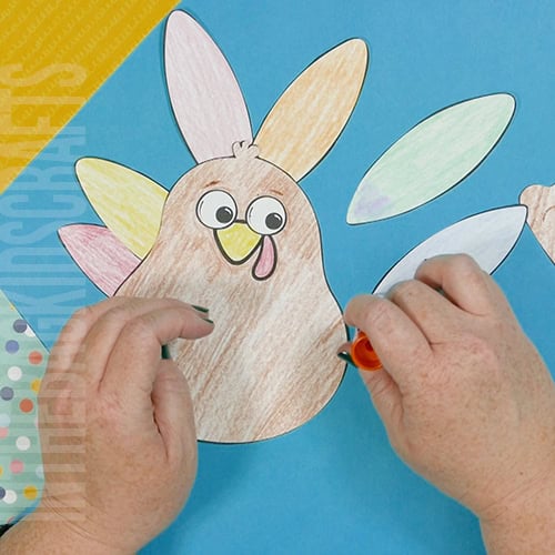 A colorful, kid-friendly turkey craft for Thanksgiving featuring a free printable template, perfect for a gratitude-themed craft for kids. step 3 assemble and add the feathers