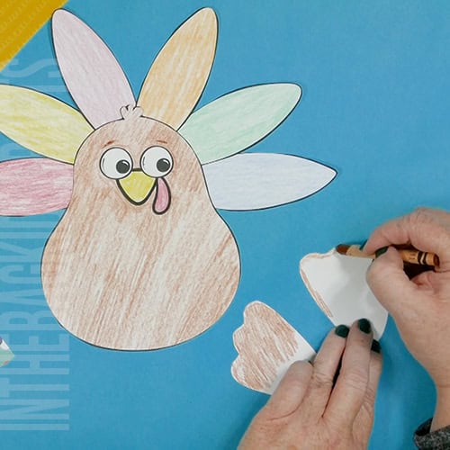 A colorful, kid-friendly turkey craft for Thanksgiving featuring a free printable template, perfect for a gratitude-themed craft for kids. step 4 prepping the wings