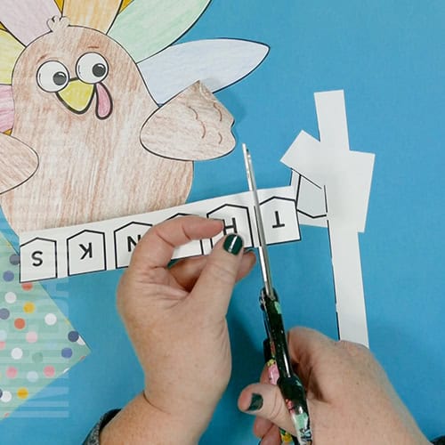 A colorful, kid-friendly turkey craft for Thanksgiving featuring a free printable template, perfect for a gratitude-themed craft for kids. step 6 make the banner