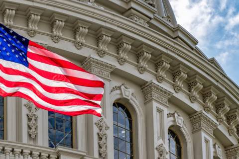 American flag flying outside a government building.