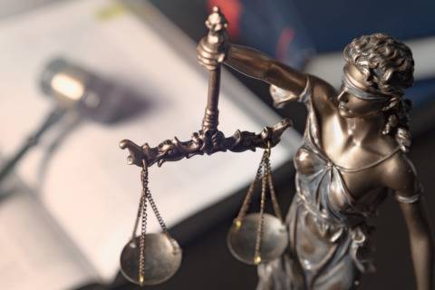 Justice statue holding scales, symbol of law and fairness.