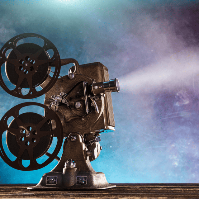High-quality vintage film projector with reels and light beam.