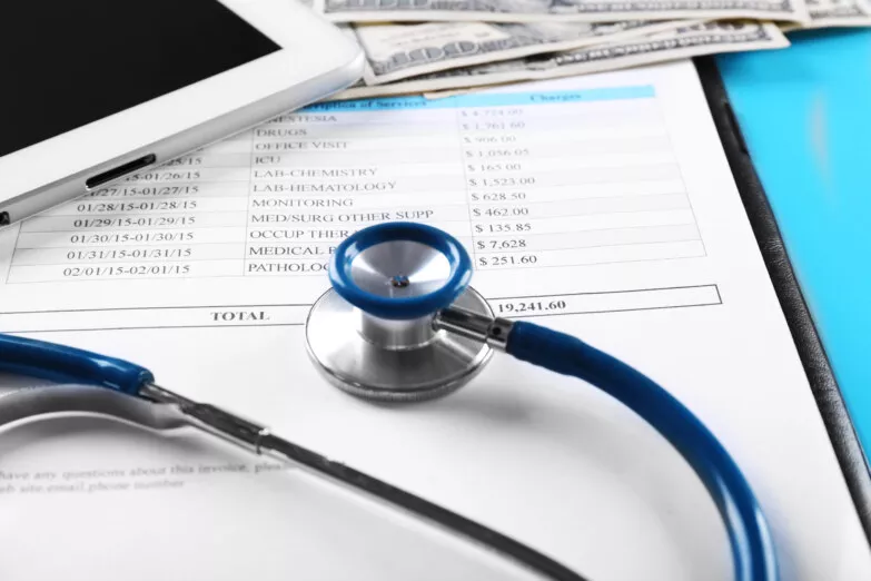 Medical billing and insurance documents with stethoscope on table.