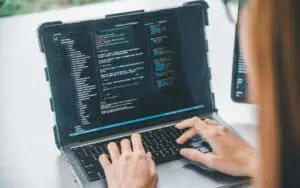 Developer working on cloud-based software coding on a laptop.