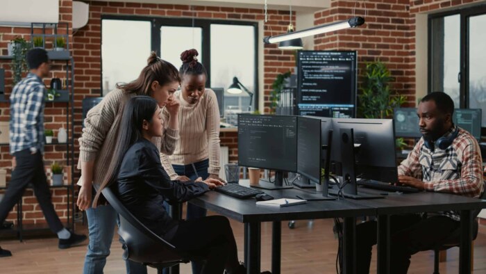 Diverse software developers collaborating in a modern office environment.