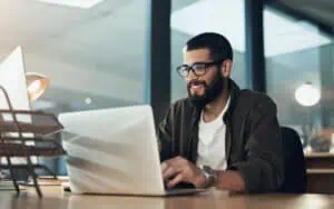 Business professional working on a laptop to overcome software scalability challenges.