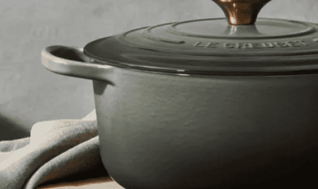 Cooking pot on wooden surface with cloth, minimalistic kitchen scene.