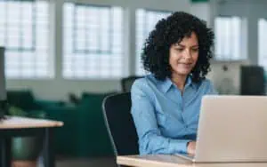 Businesswoman using a laptop to enhance business processes with Power Platform tools.