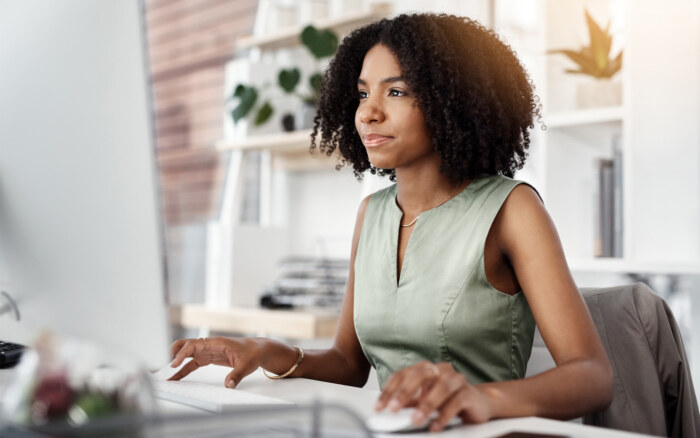 Woman working on a computer in a modern office environment.