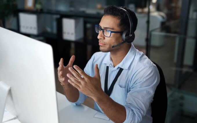 Business professional discussing IT staff augmentation strategies at a computer.