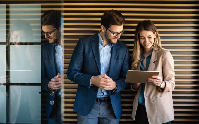 Business professionals reviewing technology assessment report in modern office.