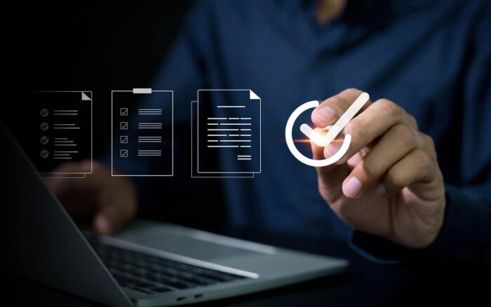 Business professional analyzing IT systems with digital icons and checklist.