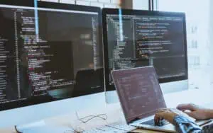 Business professional working with Excel and Power Platform on multiple screens.