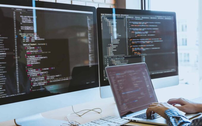 Business professional working with Excel and Power Platform on multiple screens.