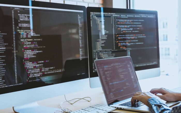 Business professional working with Excel and Power Platform on multiple screens.