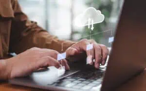 Business professional working on cloud technology with digital icons and cloud graphics.