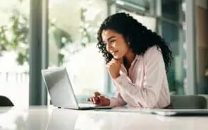 Businesswoman analyzing data integration risks on her laptop.