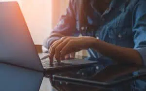 Person managing SharePoint content on laptop for organized information control.