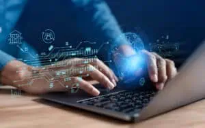 Hands typing on a laptop with digital tech icons and globe overlay, representing IT solutions.