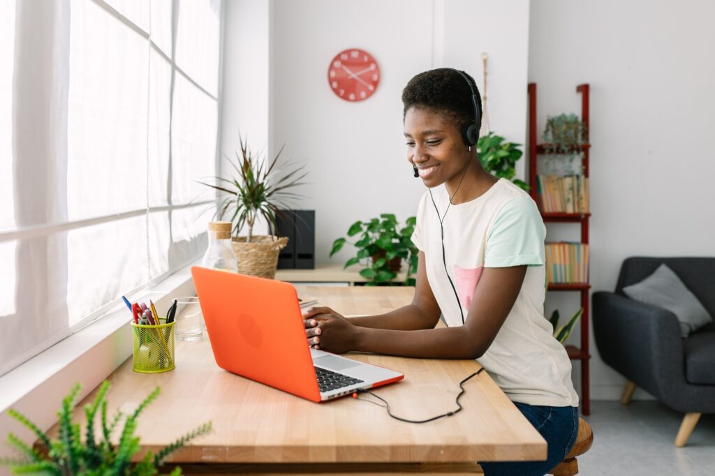 Young african woman with headset working from home office