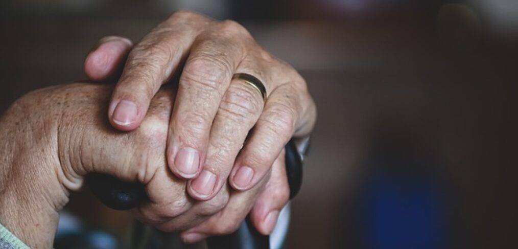 elder abuse - hands resting on a cane
