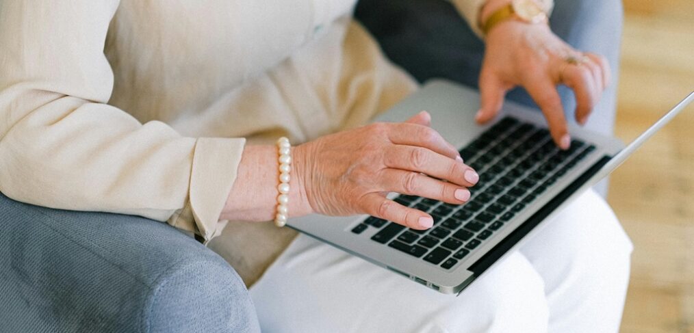 Elderly woman looking at laptop