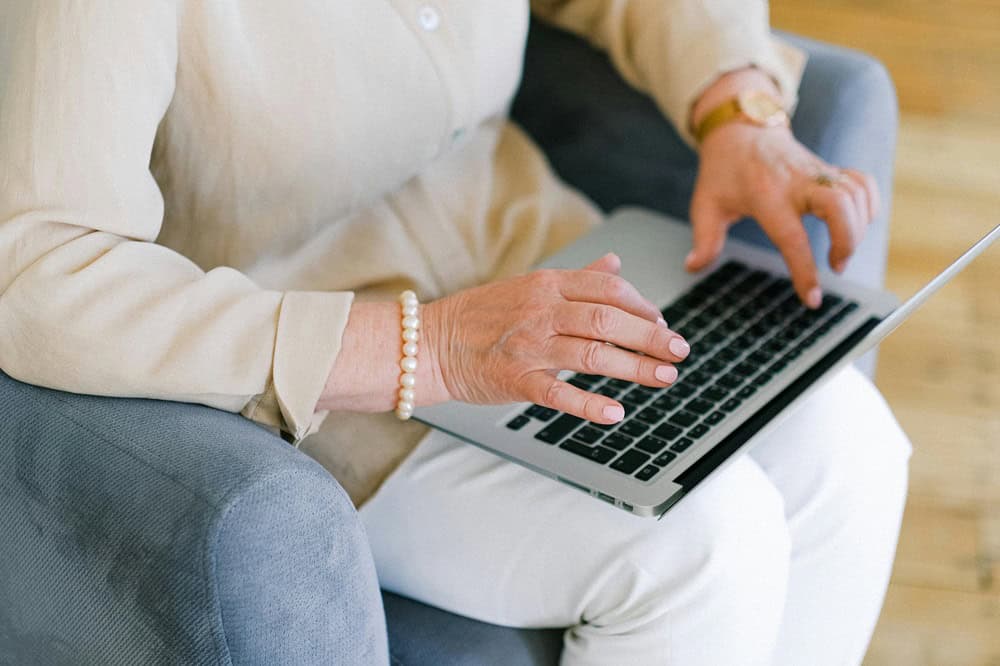 Elderly woman looking at laptop