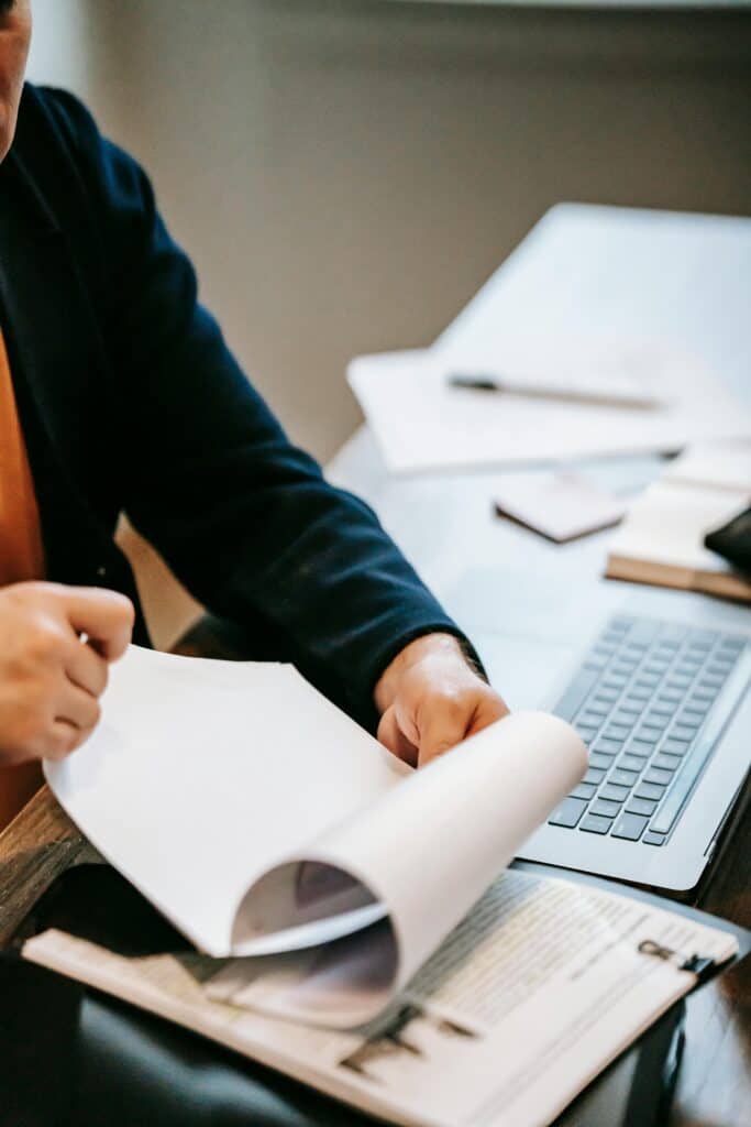 person in suit working at desk reviewing papers