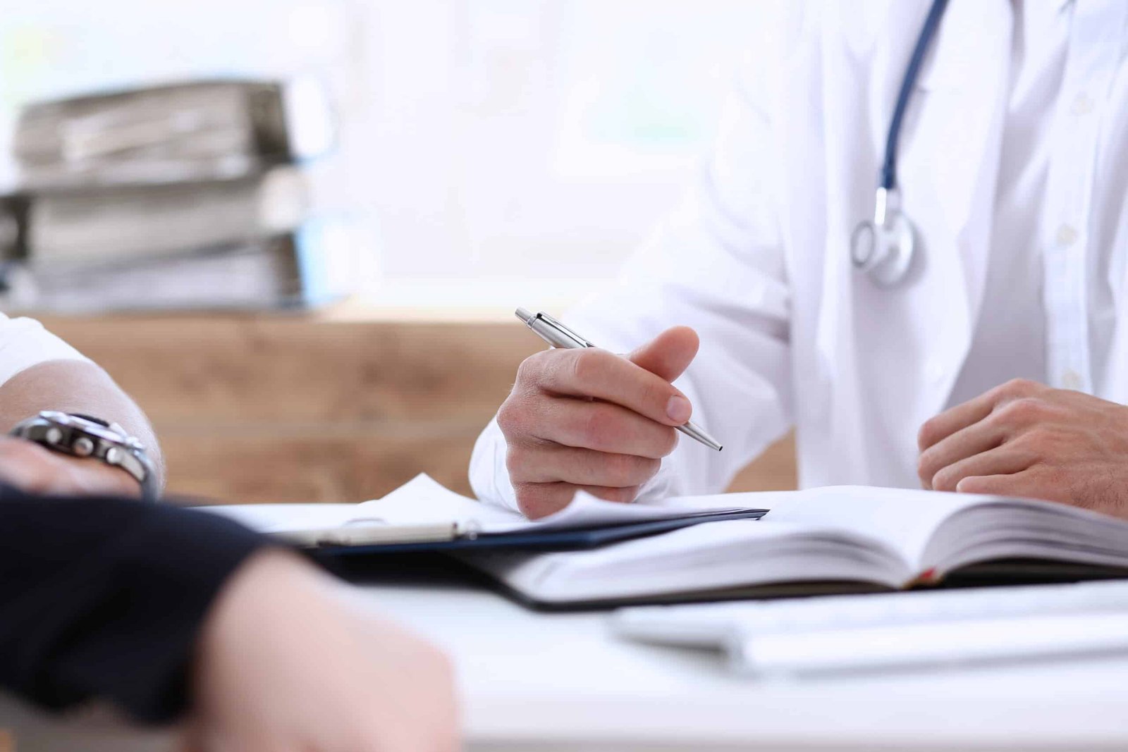 Male family doctor listen carefully young couple in office