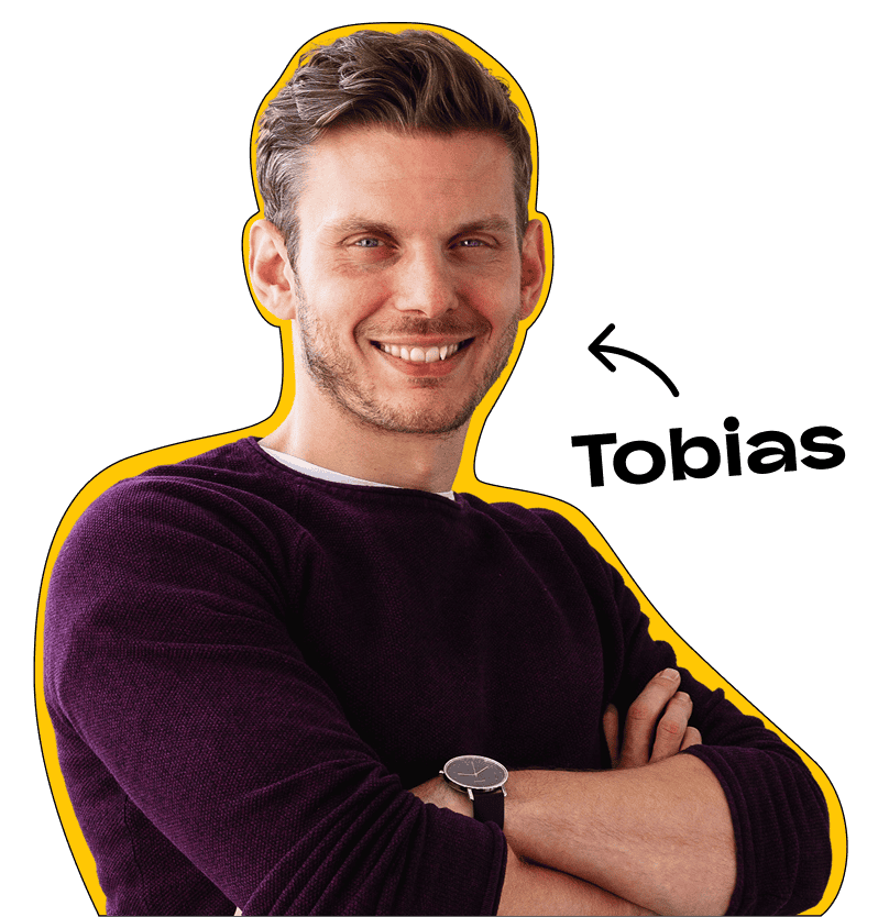 Tobias Roppelt steht mit seinen Armen verschränkt und lächet in die Kamera.