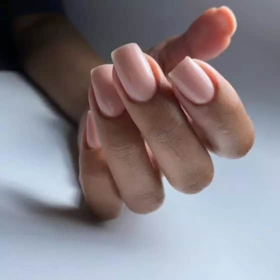 Elegante nagelverzorging met natuurlijke, glanzende nagels en perfect gevormde nagelriemen.