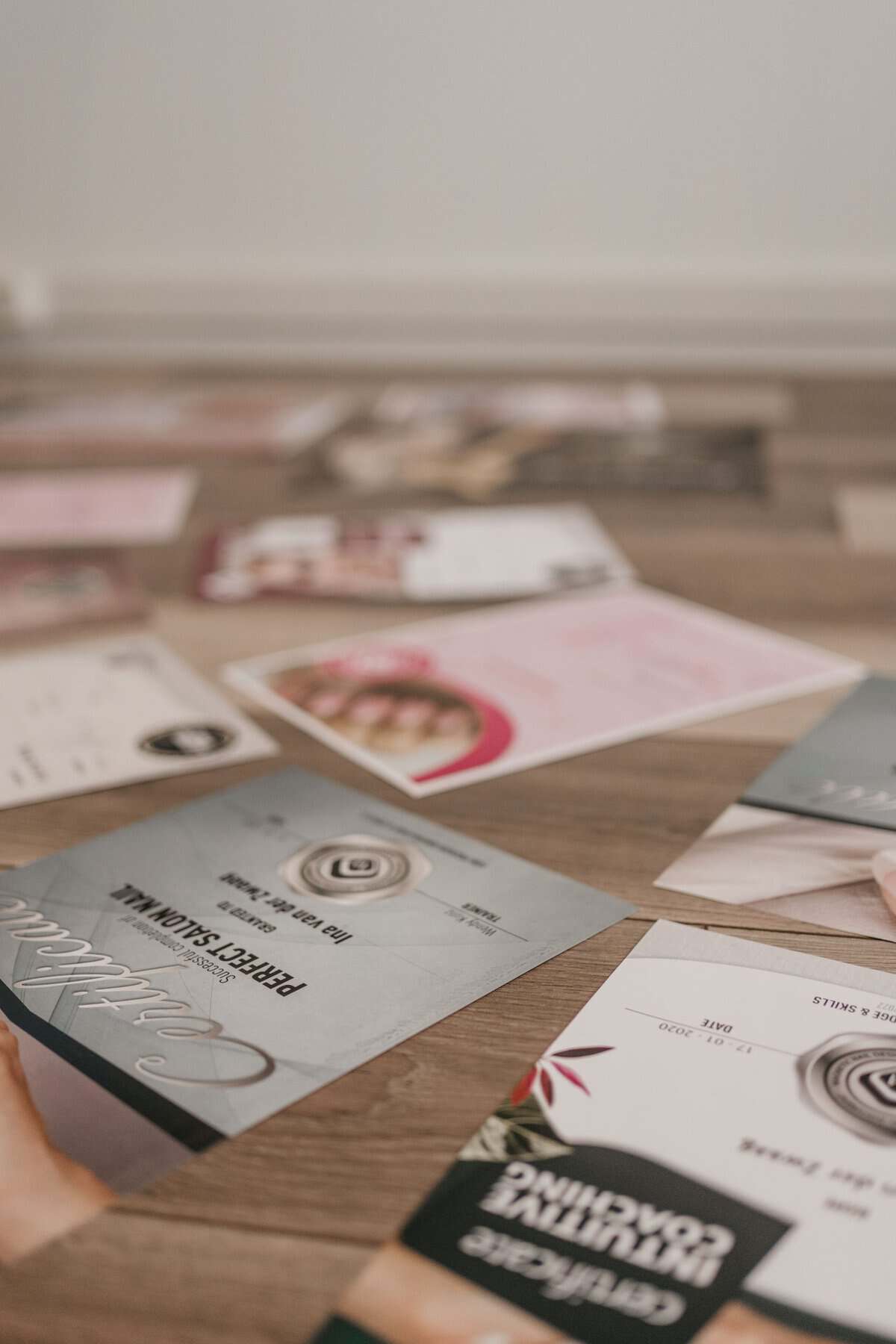 Elegante visitekaartjes en promotiemateriaal voor Indiki Nails op een houten tafel.