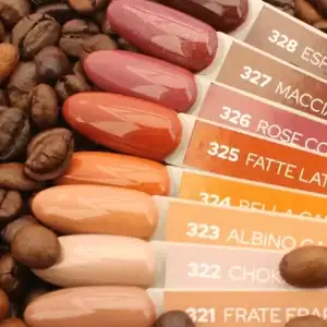 Gellak kleurenstalen met koffiebonen achtergrond, inclusief diverse tinten zoals bruin, roze, oranje.