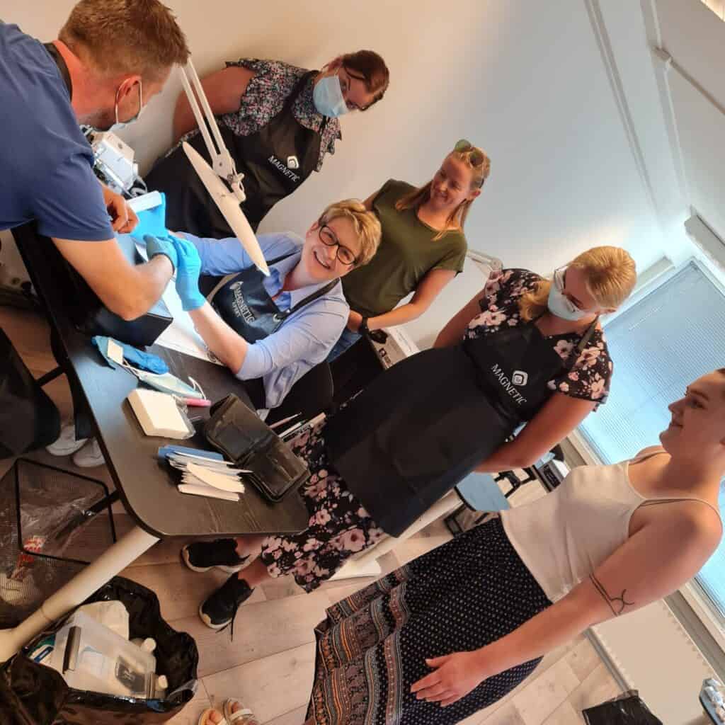 Huidverzorgingsbehandeling door professionals in een kliniek, met meerdere mensen en medische appara.