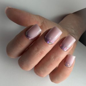 Gelnagels met glitters en zachte roze kleur op natuurlijke nagels.