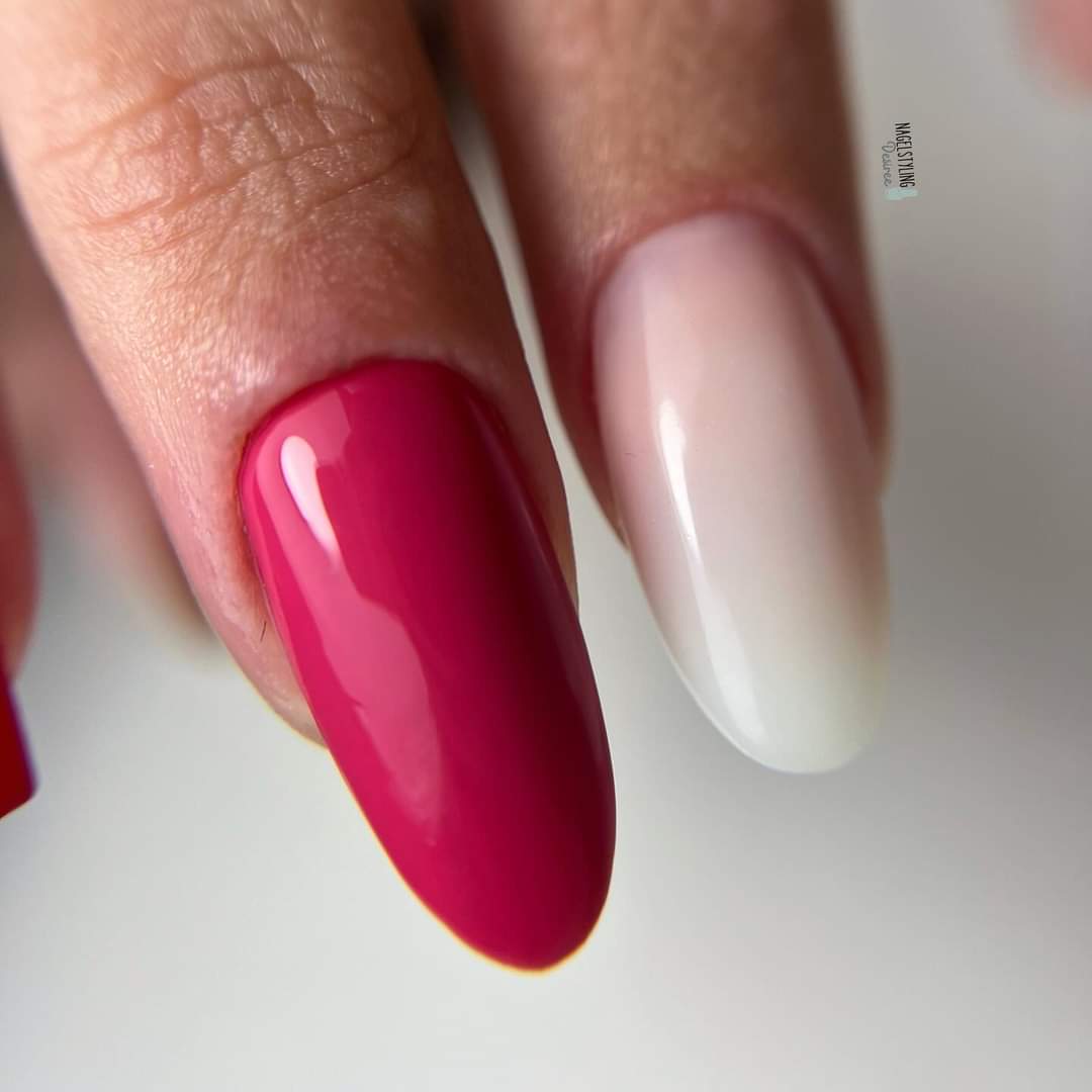 Gekleurde gelnagels met roze en wit design op natuurlijke nagels.