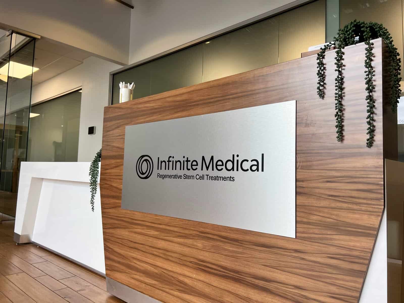 Infinite Medical clinic reception desk with wooden accents and modern decor.