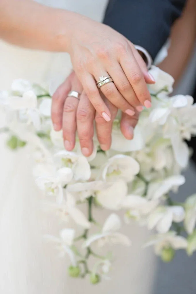 Nahaufnahme von Hochzeitsringen auf einem Blumenstrauß bei einer Hochzeit.