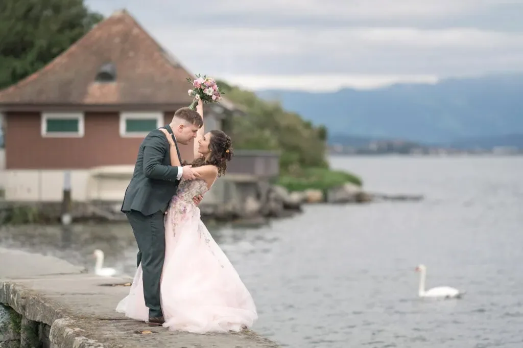 Romantisches Hochzeitsfoto am See mit verliebtem Brautpaar.