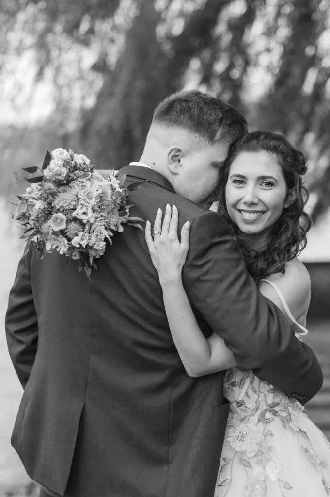 Hochzeitspaar umarmt sich liebevoll im Park, romantische Stimmung, professionelle Hochzeitsfotografi.