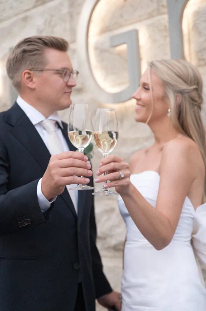 Hochzeitsfoto von Braut und Bräutigam beim Anstoßen mit Sekt.
