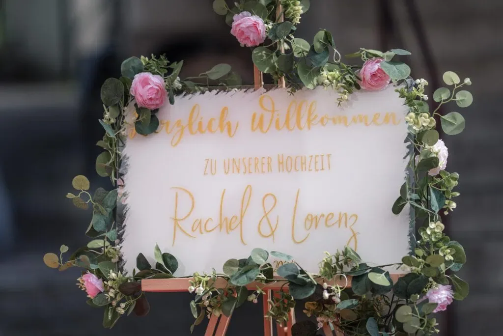 Willkommen auf der Hochzeit von Rachel & Lorenz mit Blumenkranz.