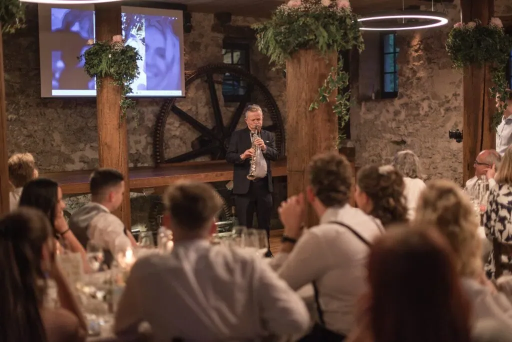 Hochzeitsfotografin bei einer emotionalen Rede in rustikalem Ambiente.