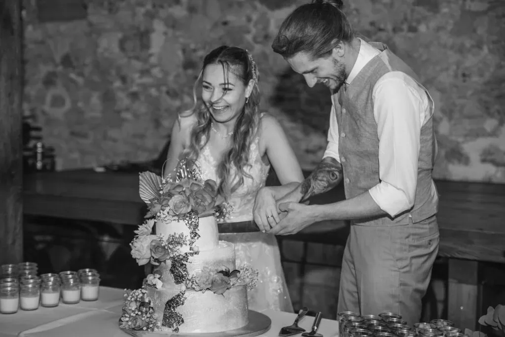 Hochzeitspaar schneidet die Torte bei einer emotionalen Feier.