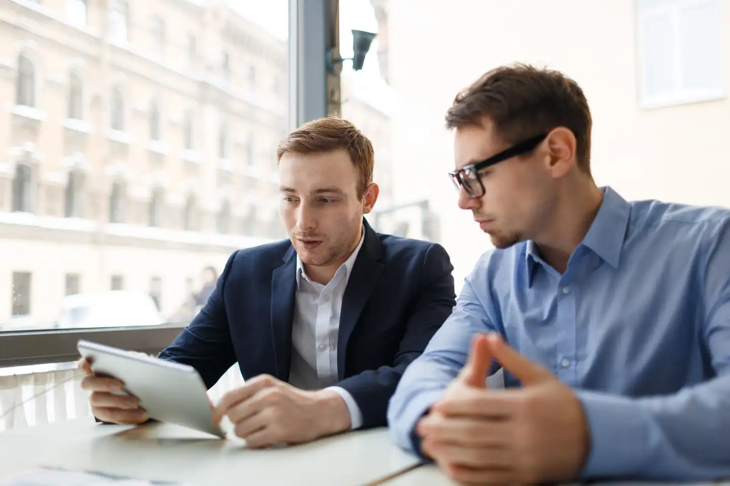 Dos empresarios revisan una consultoría ISO 9001 en una oficina, representando cuánto cuesta certificar ISO 9001 en 2025.
