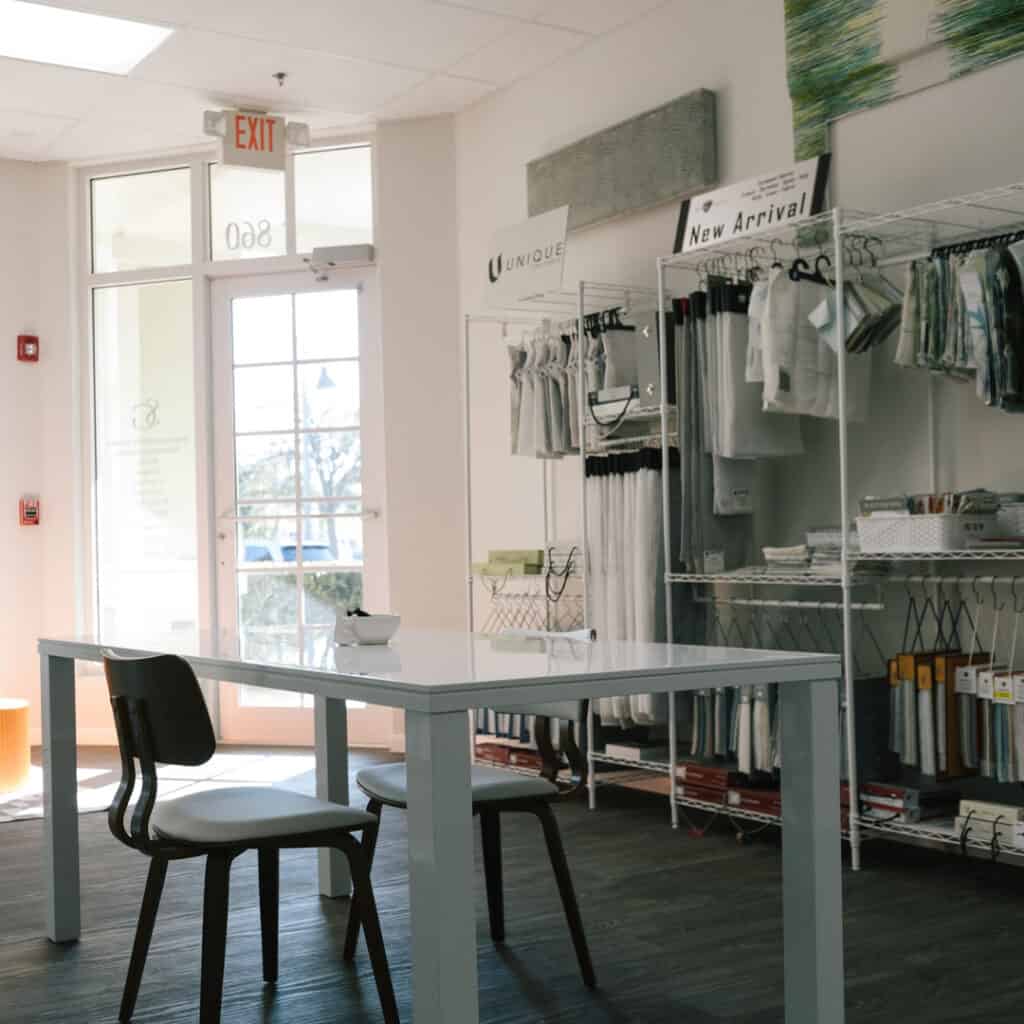 Modern store interior with fabric displays and a meeting table, showcasing quality window treatments and shade fabrics for home decor at In The Shade, Florida.